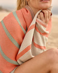 Lane Turkish towel in Peach Cream – wrapped around model while seated in a relaxed pose