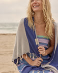 La Luna Turkish towel in Indigo – smiling at seaside with towel over shoulders