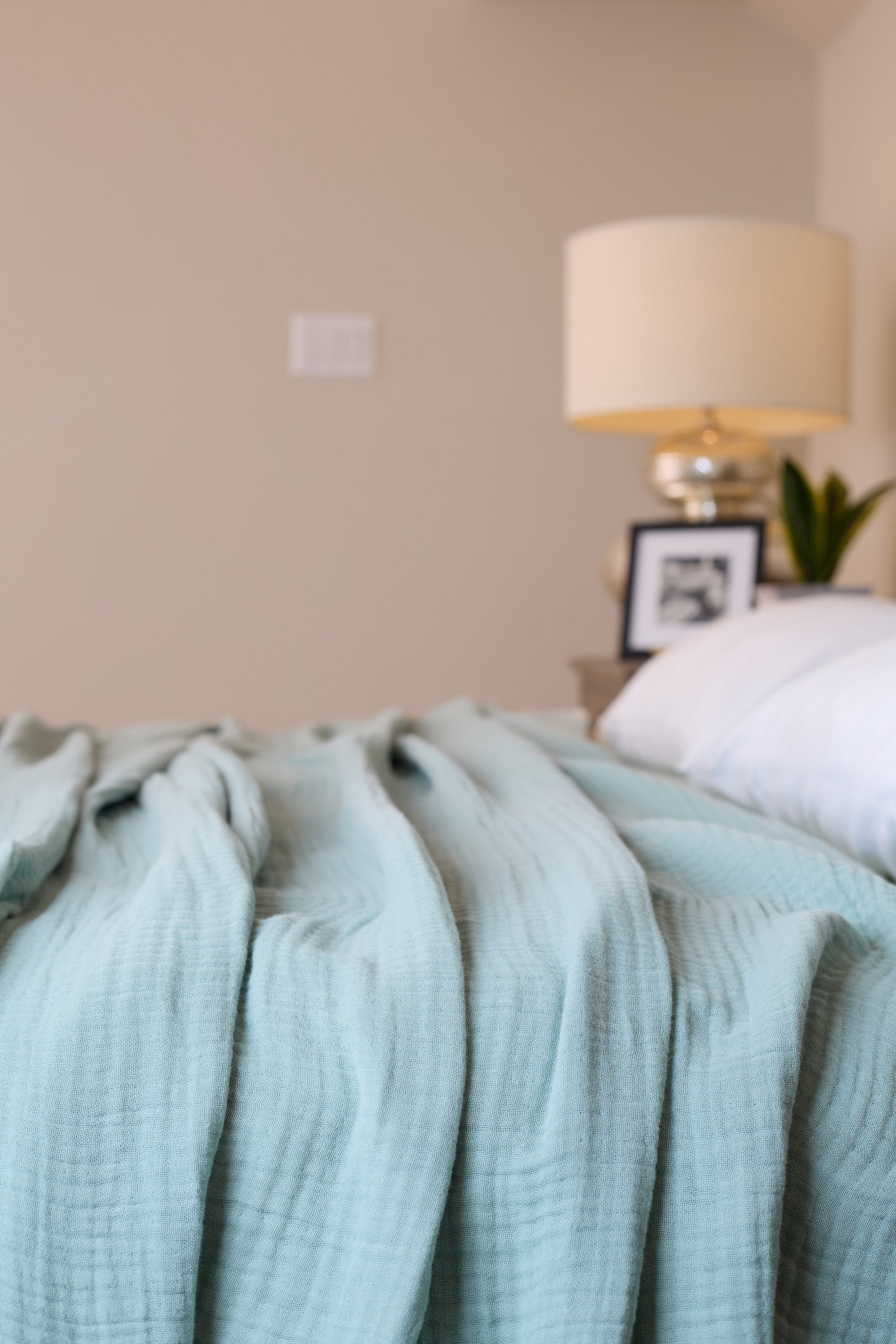 Summer Blanket in Sage – Blanket spread on bed for lifestyle view