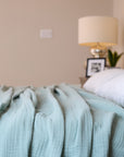 Summer Blanket in Sage – Blanket spread on bed for lifestyle view