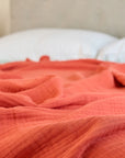 Summer Blanket in Terra – Blanket spread on bed for lifestyle view