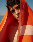 Comb Turkish towel in Sicilian Orange – draped over head with bold gaze, poolside