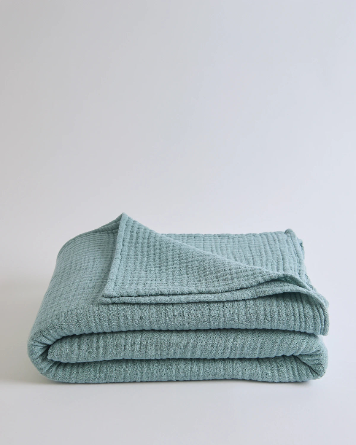 Summer Blanket in Sage – Folded blanket with label visible and soft sage color fabric