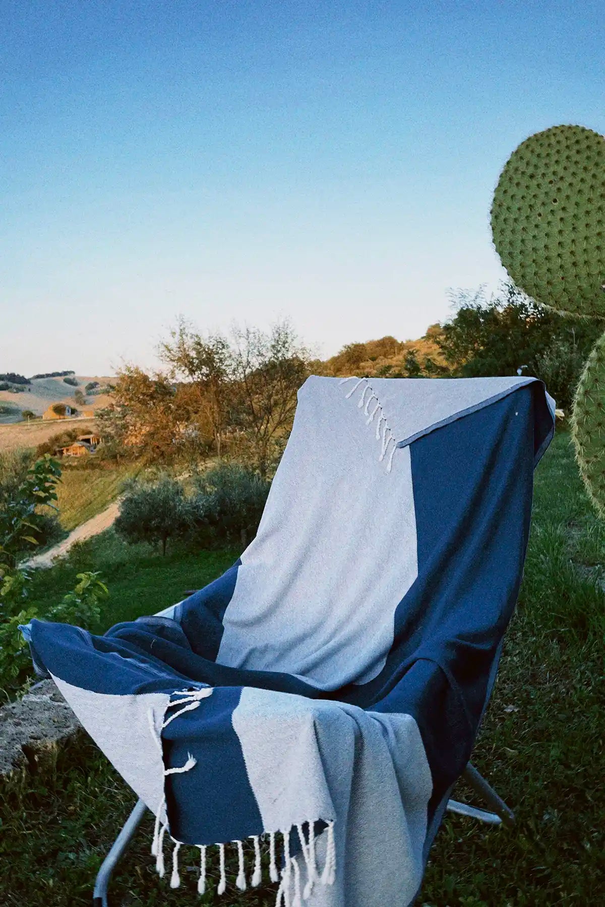 La Luna Turkish towel in Indigo – laid over folding chair at campsite for soft back support